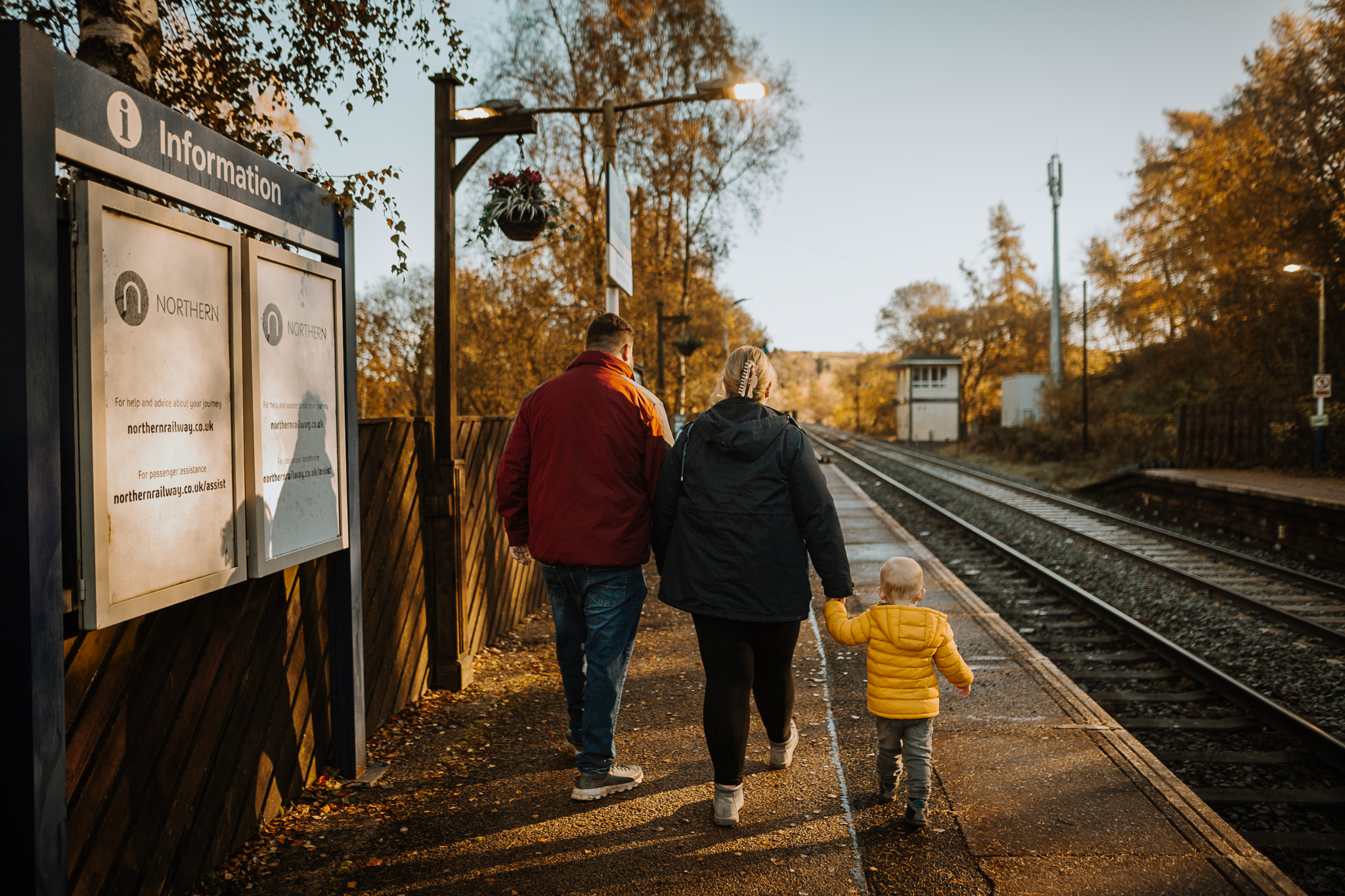 Family having a day out in the autumn sunshine at a railway station