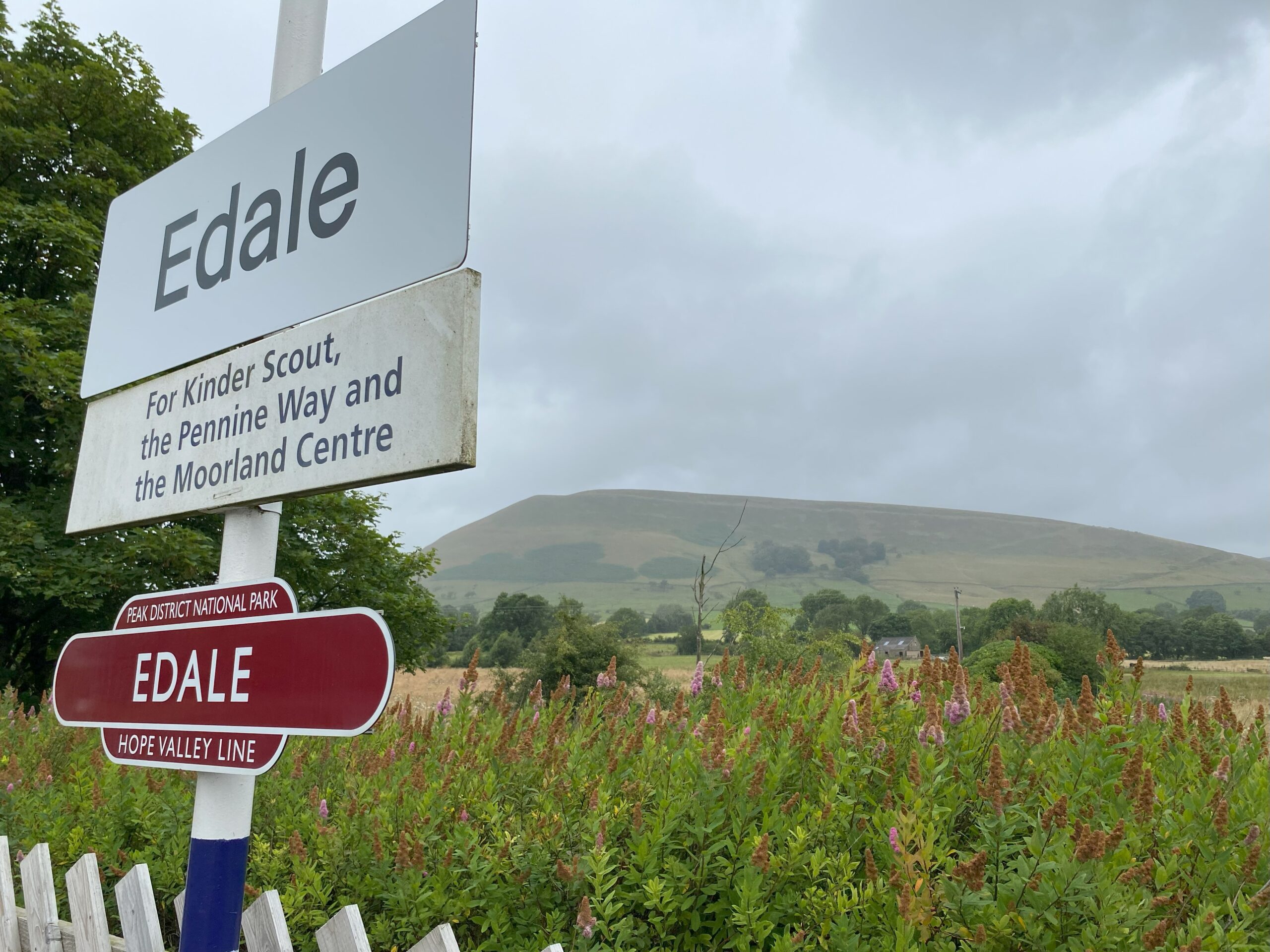 Station sign with rolling hills in the background