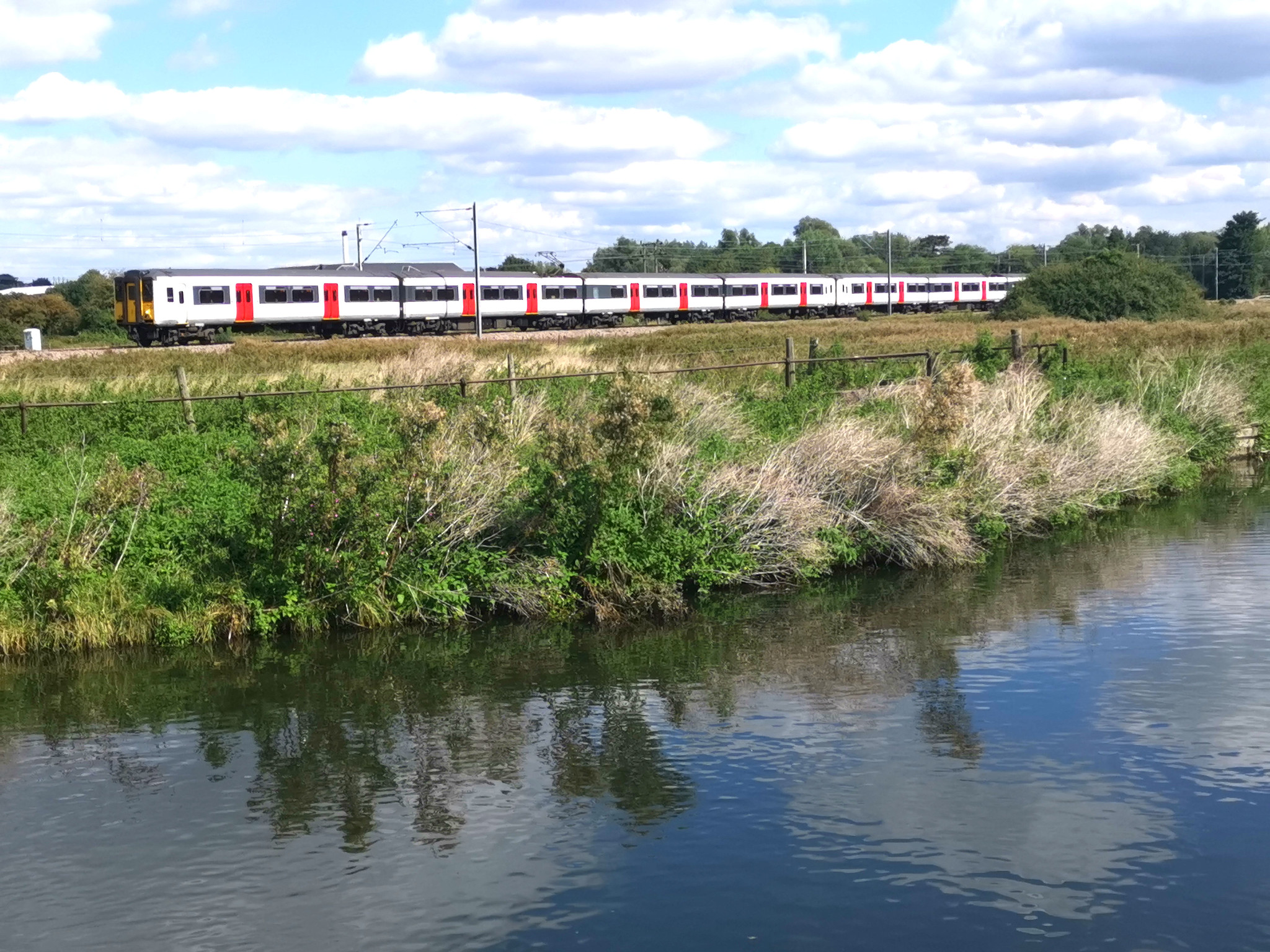 A train running alongside the New River Path near Hertford East