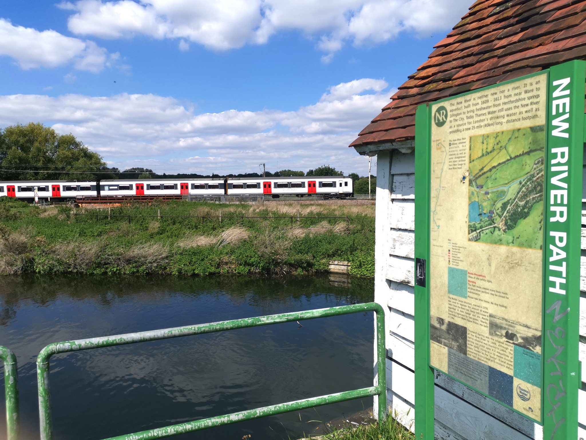 A train to London running alongside the New River Path near Hertford East