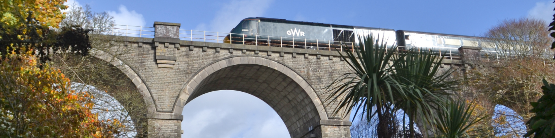 GWR train travelling across viaduct with blue sky