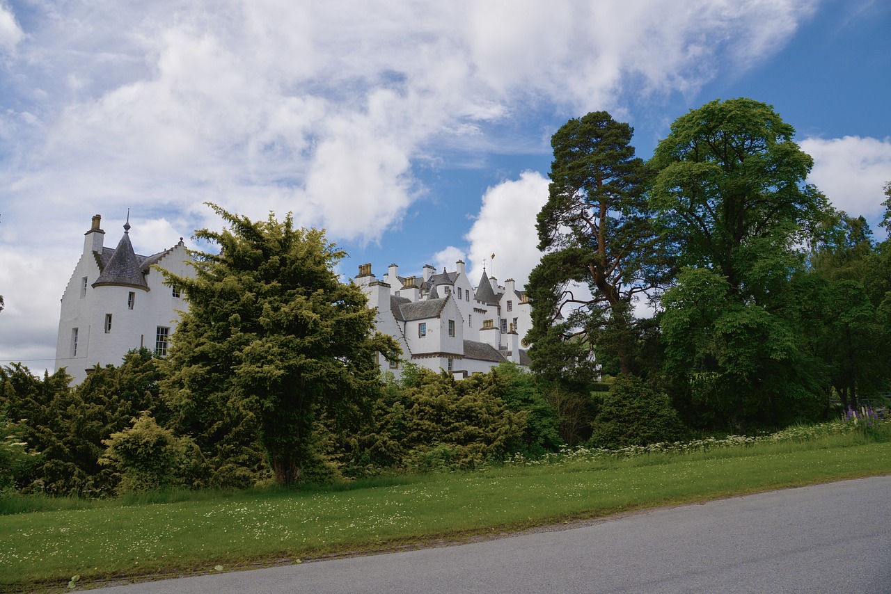 Blair Atholl Castle just visable through lush green Scottish Highland trees