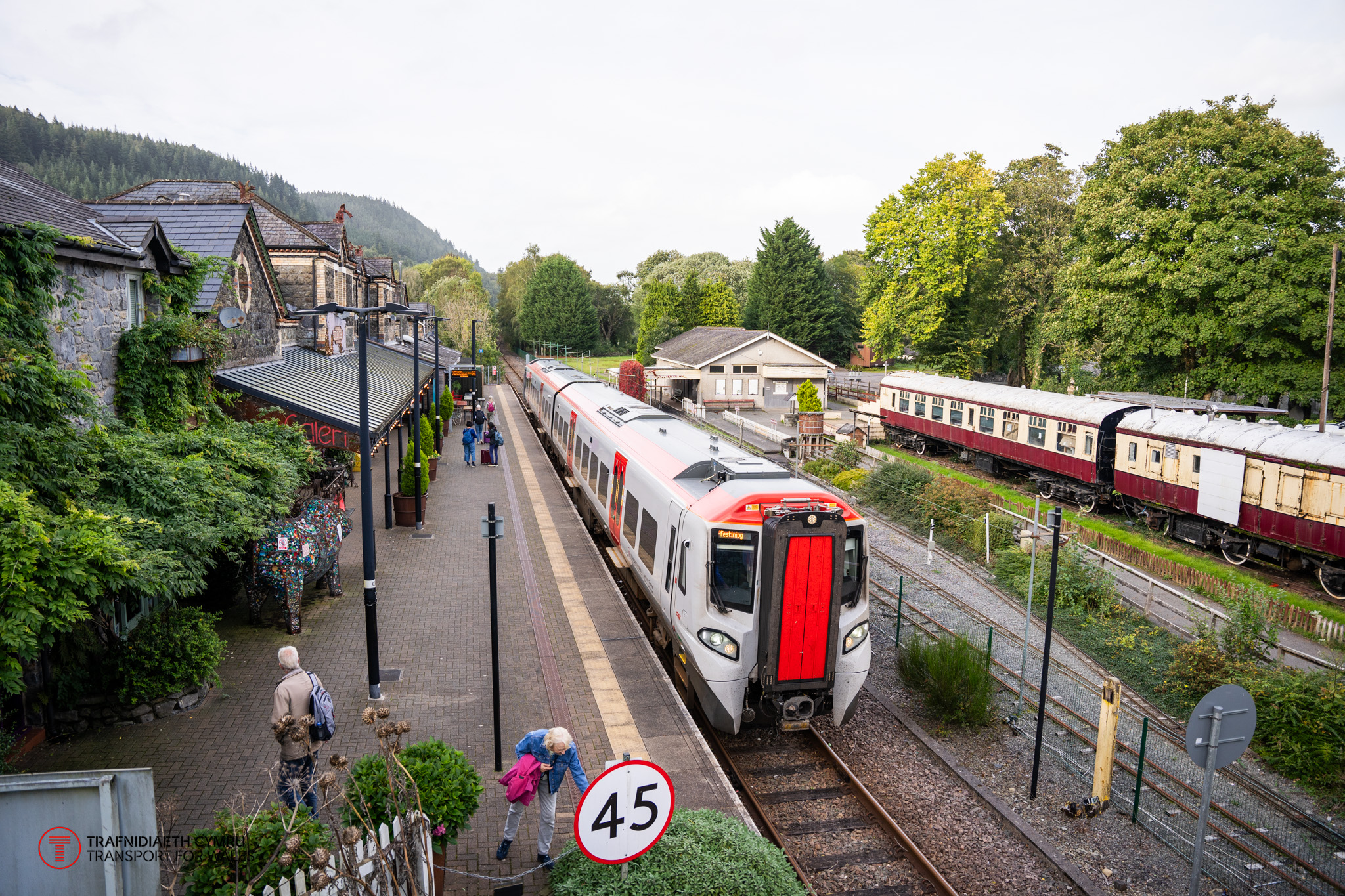 Train at Betws-y-Coed station with heritage railway carriage in the background