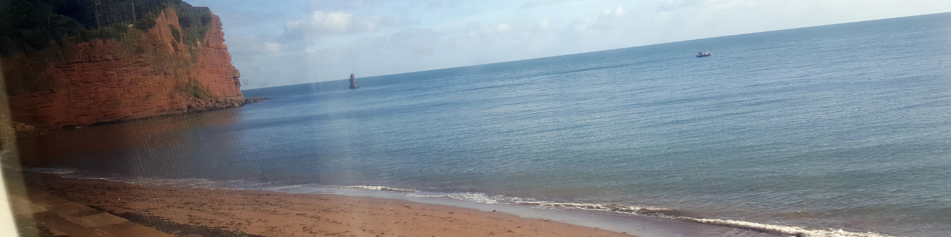 View from the train in Cornwall looking out to golden sandy beaches and blue sea