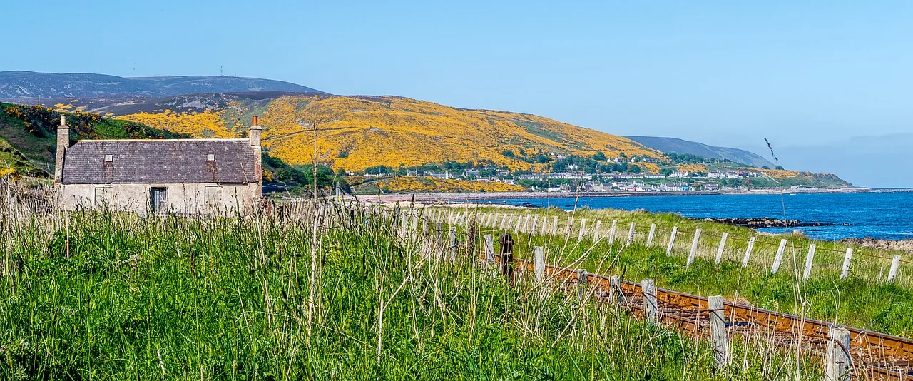 View of water and hillside on a sunny day in Helmsdale, Far North Line