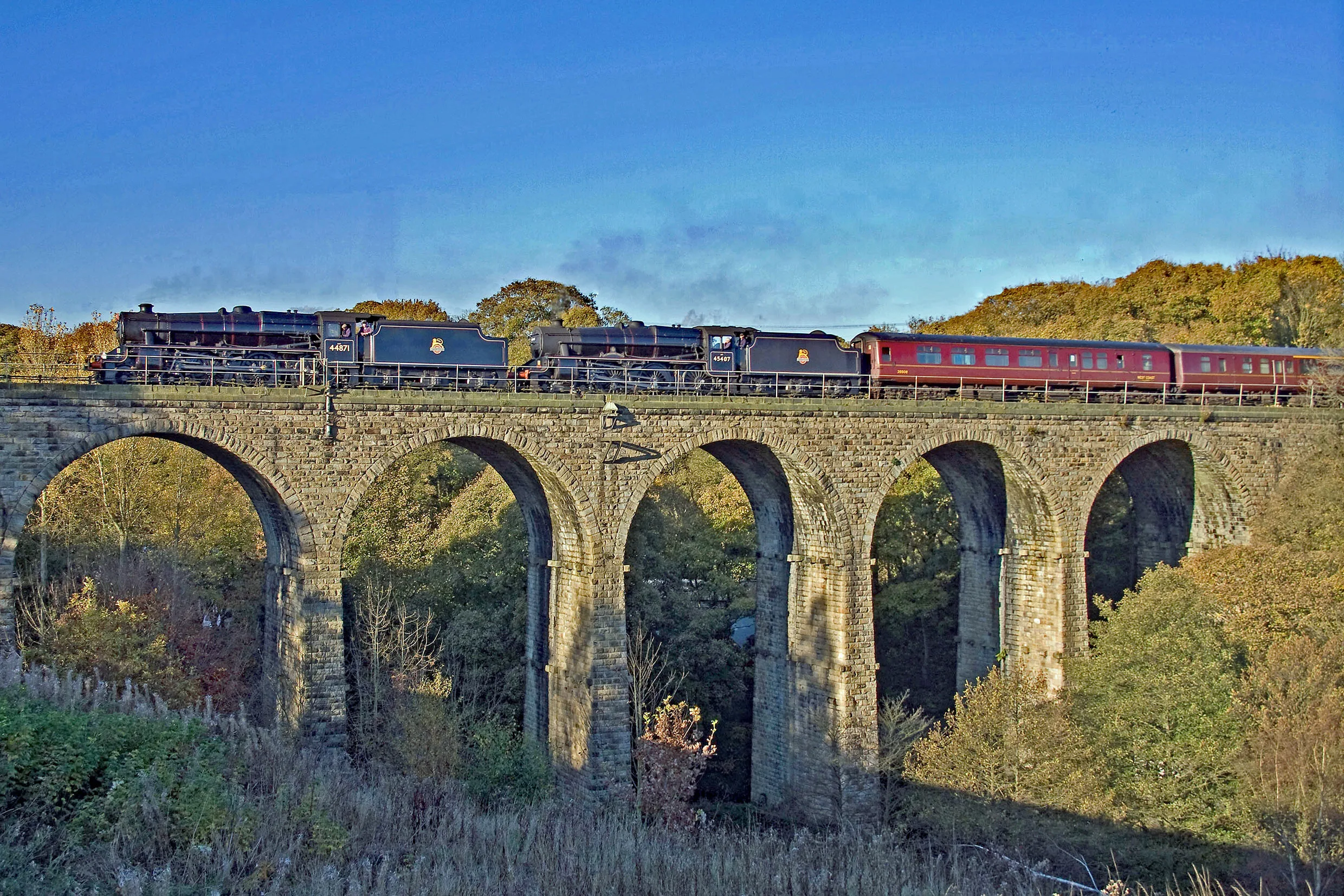 Steam train travelling along a viaduct on a sunny day | Penistone Line