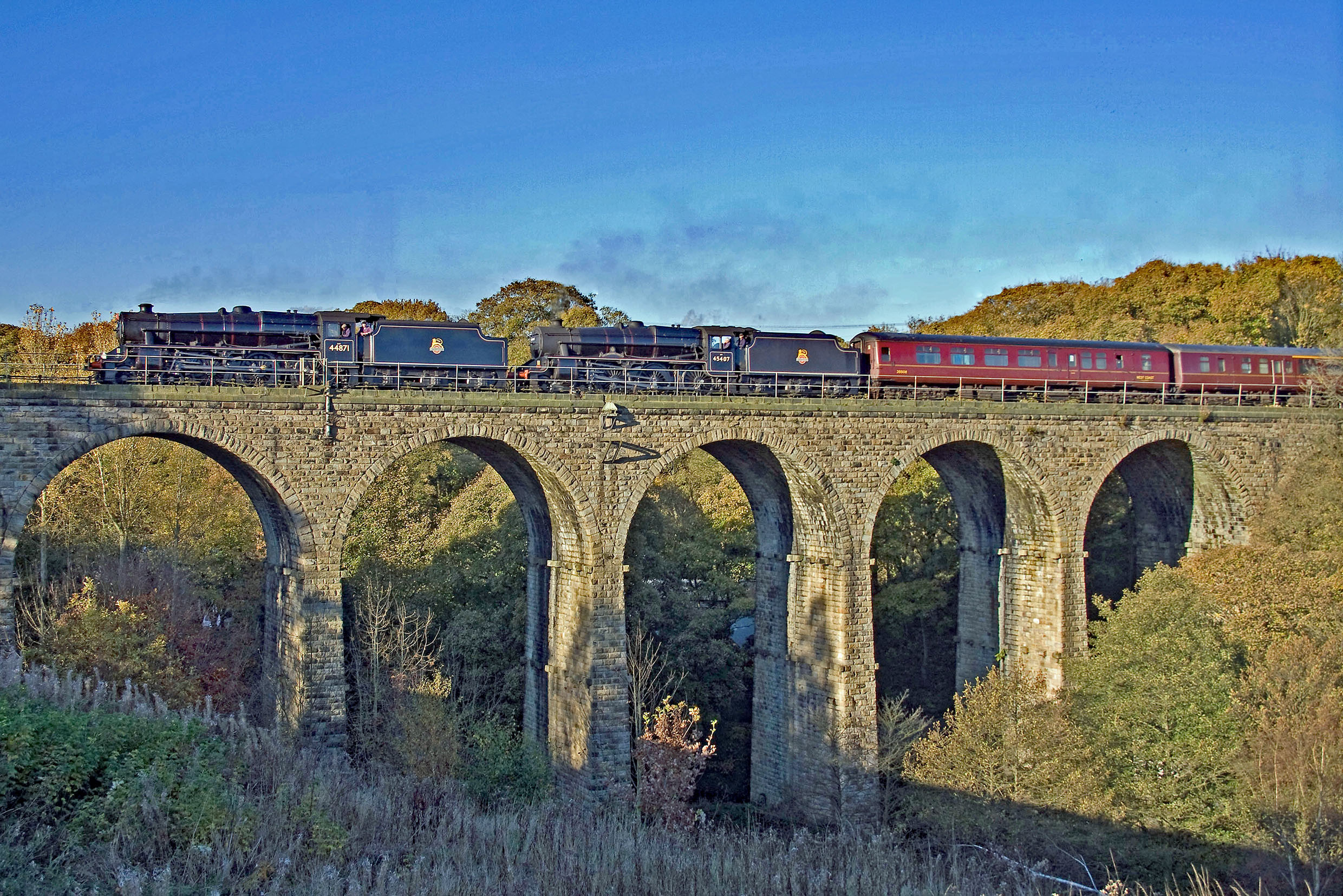 Steam train travelling along a viaduct on a sunny day | Penistone Line