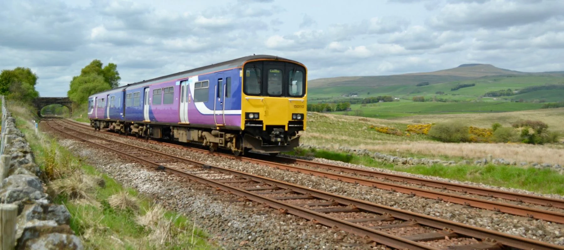 Train passing Ingleborough, near Clapham along the Bentham Line. Yorkshire & North East UK