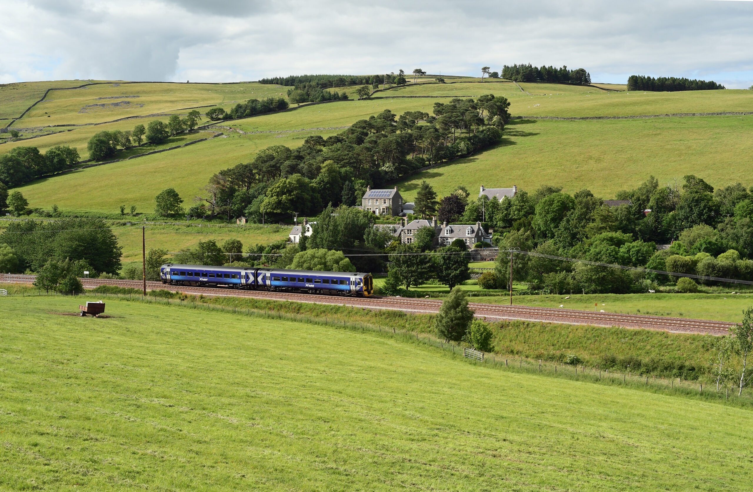 Train travelling through lush green Scottish landscapes, Borders Railway - Discover 8 favourite Scottish railways this Burns Night