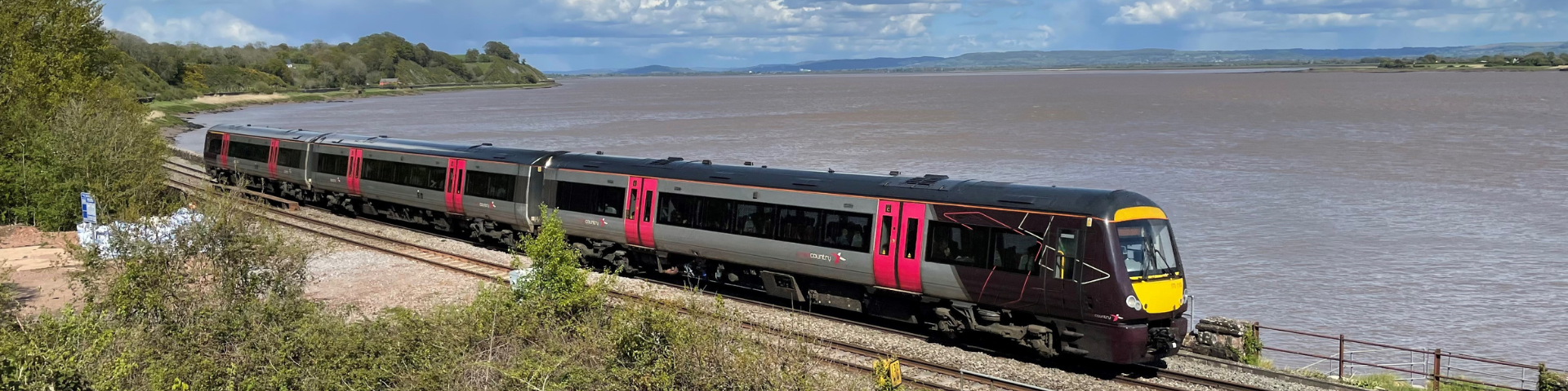 Cross Country train passing the side of the Severn Estuary on a sunny day