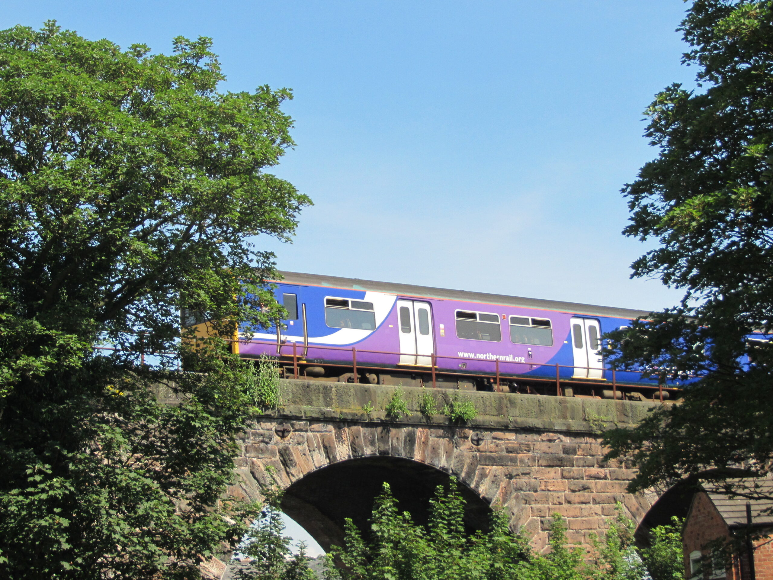 Train travelling on viaduct over Hunts Lock along the Mid Cheshire Line. North West UK.