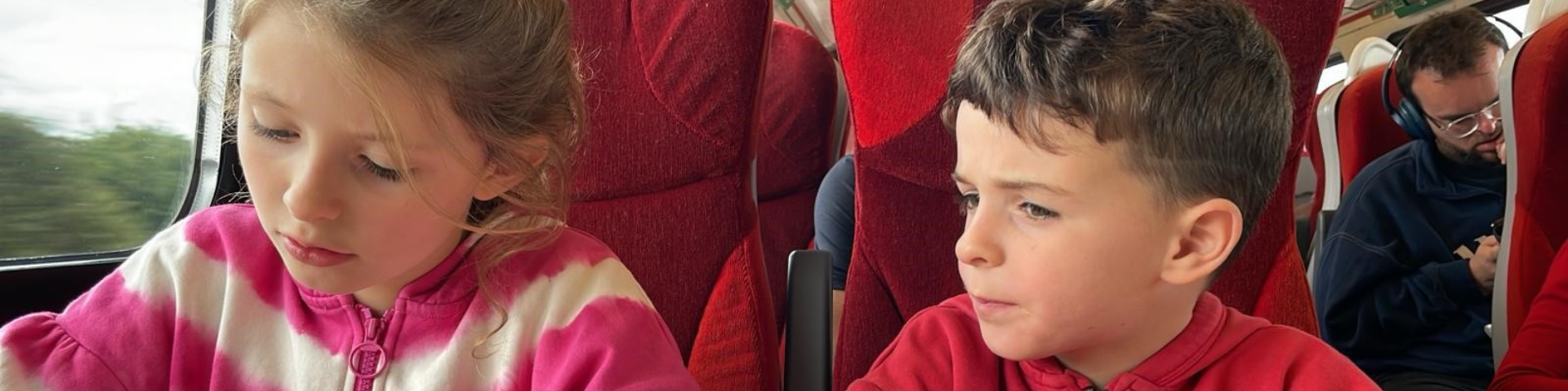 Children sat on the train doing activities