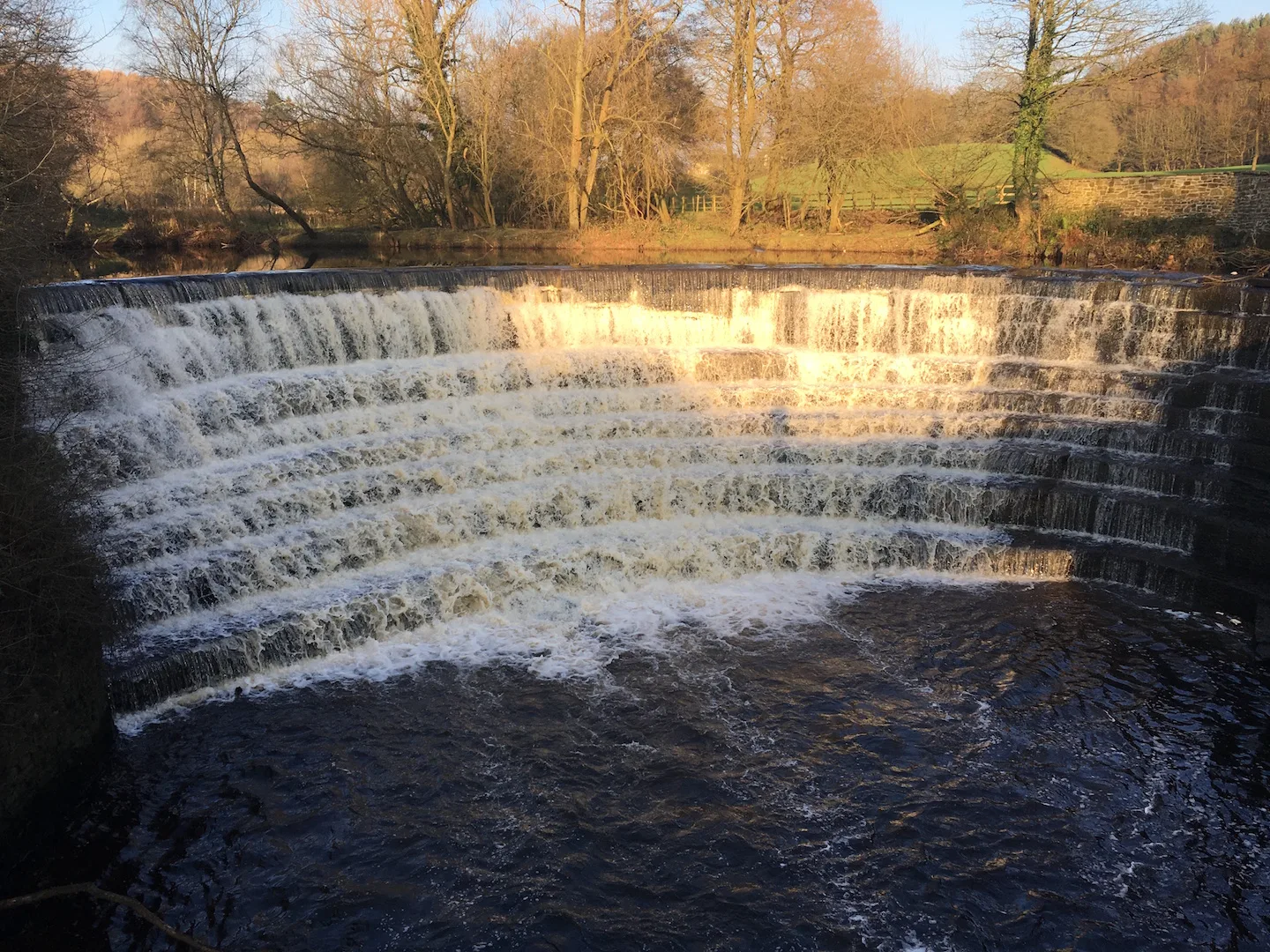 View of weir at Etherow country park in the winter sun