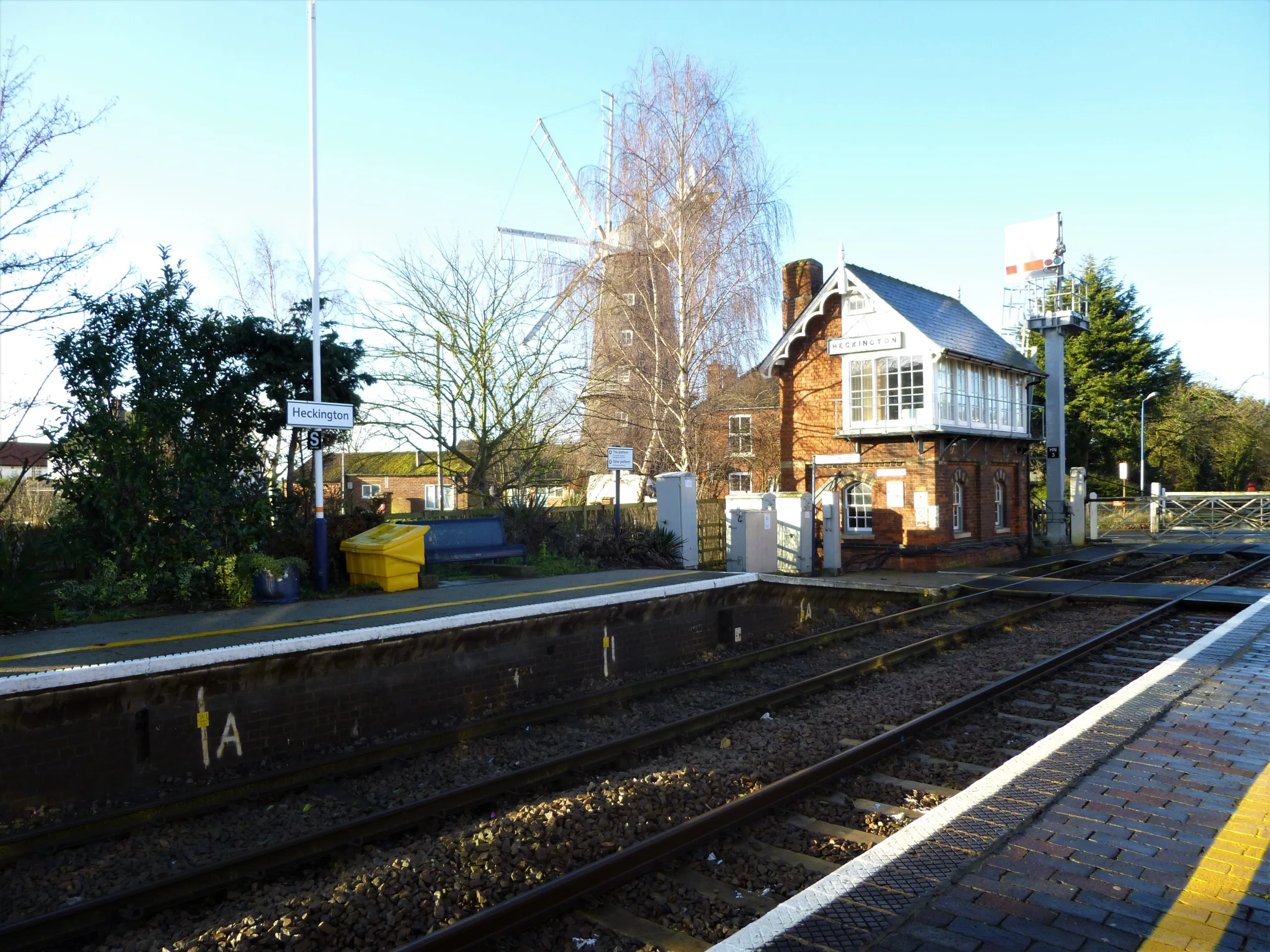 View of train station and tracks with windmill in background