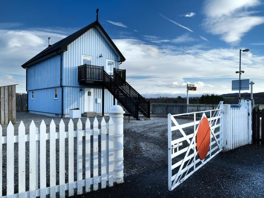 Signal box next door to a railway with blue sky