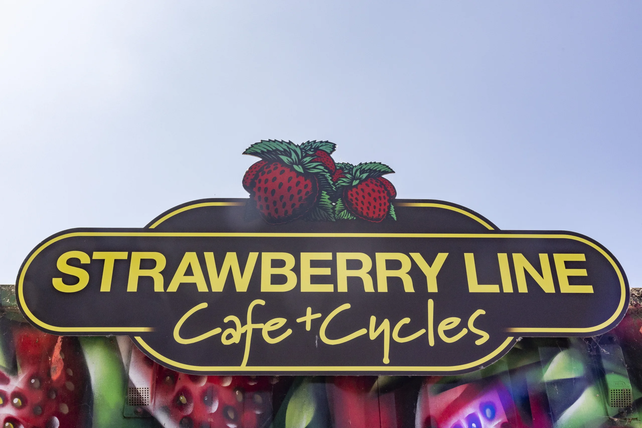 Strawberry Line cafe and cycles sign with blu sky in background