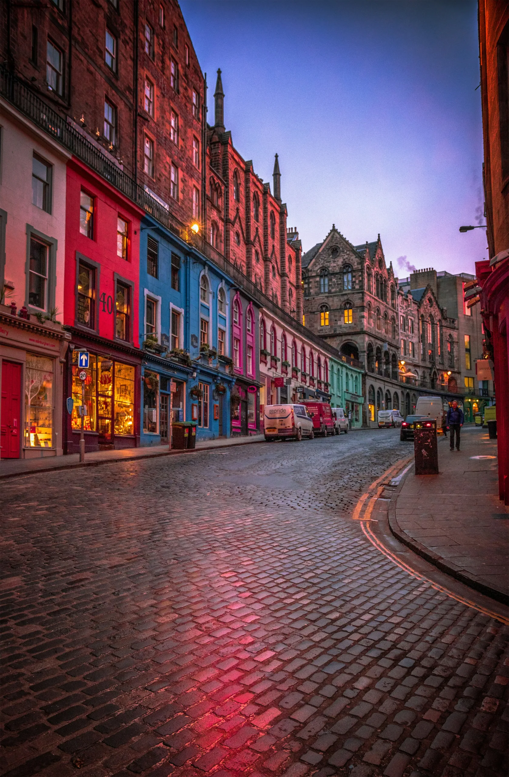View of a cobbled street with colourful buildings either side at dusk | Scotland walking and wheeling | Literary trails and tales by rail