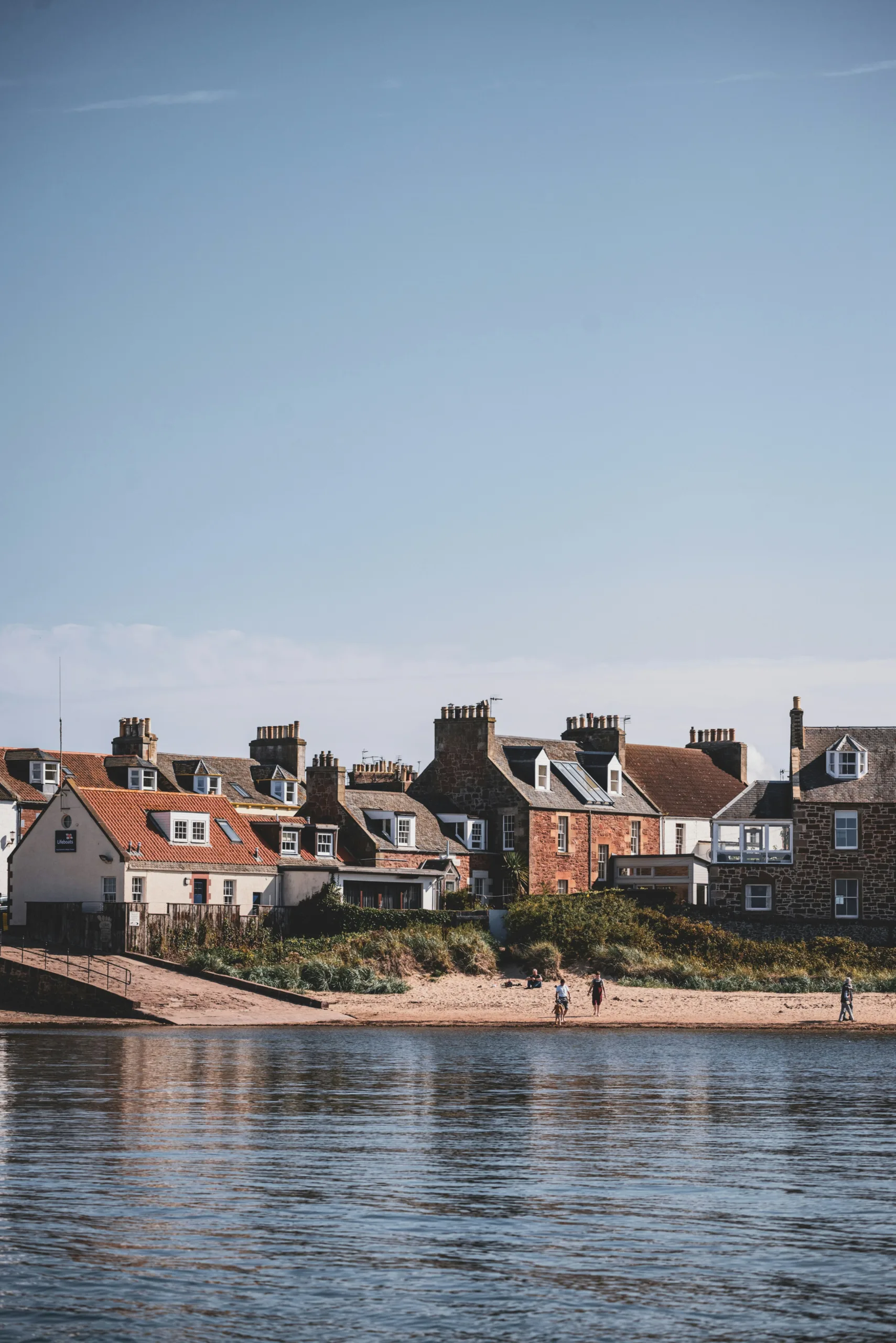 Picturesque houses nestled by water on a blue sky day | North Berwick by train