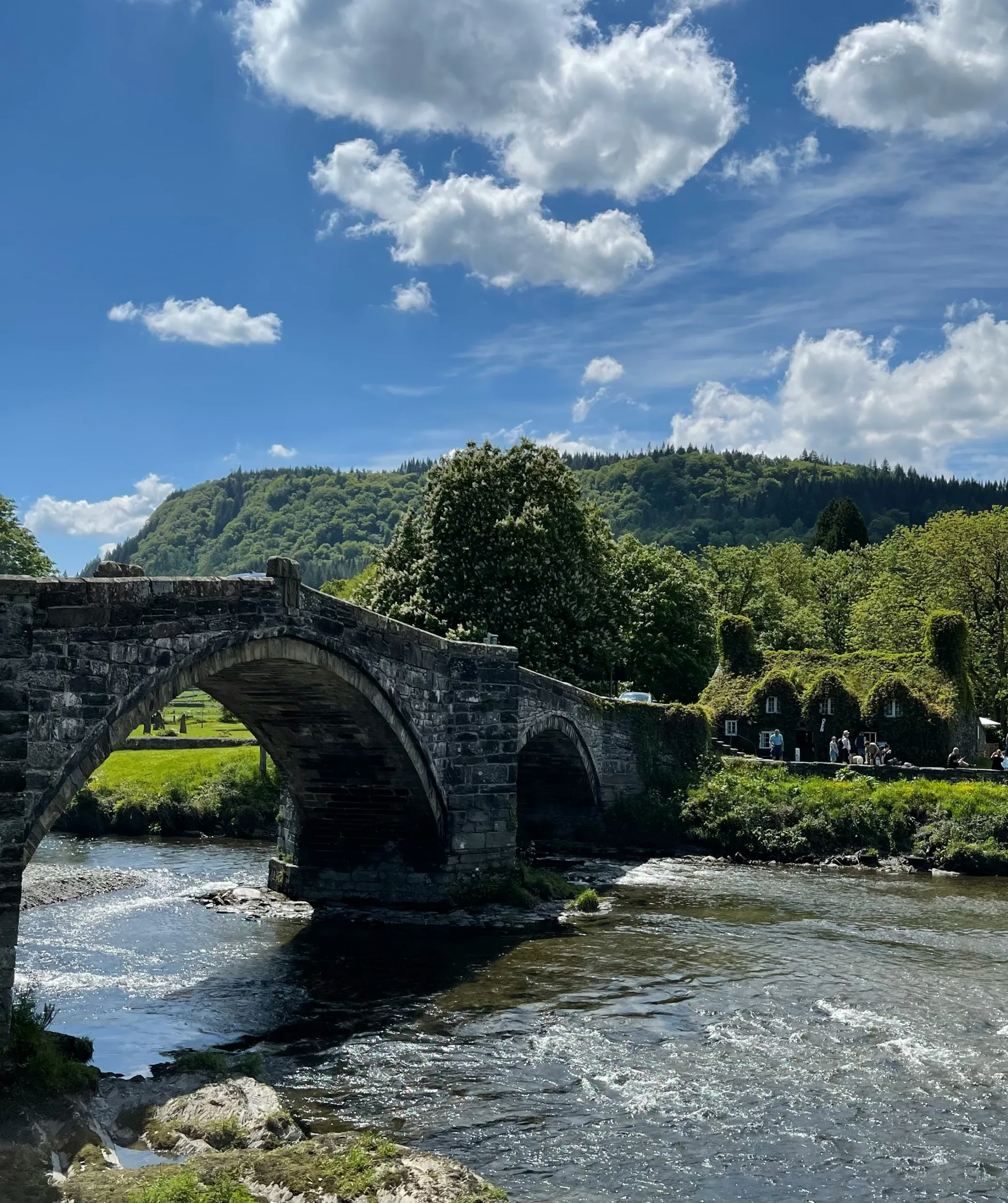 Stone bridge over the river leading to a traditional house covered in greenery looking straight from a fairytale. Tu Hwnt I'r Bont, Llanrwst | Wales