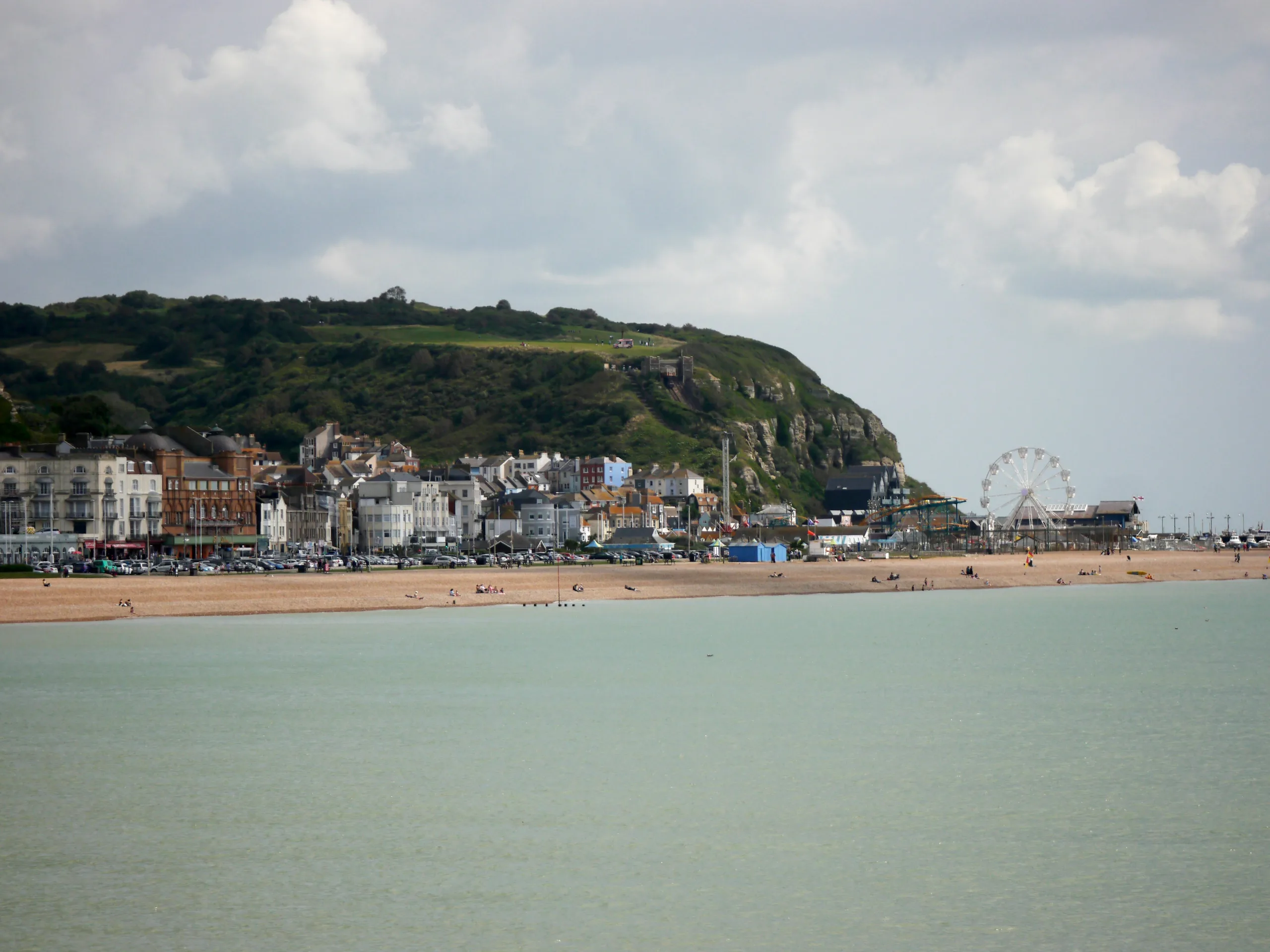 View from the pier looking back towards the coast with the sea, golden beach and seaside town. 
